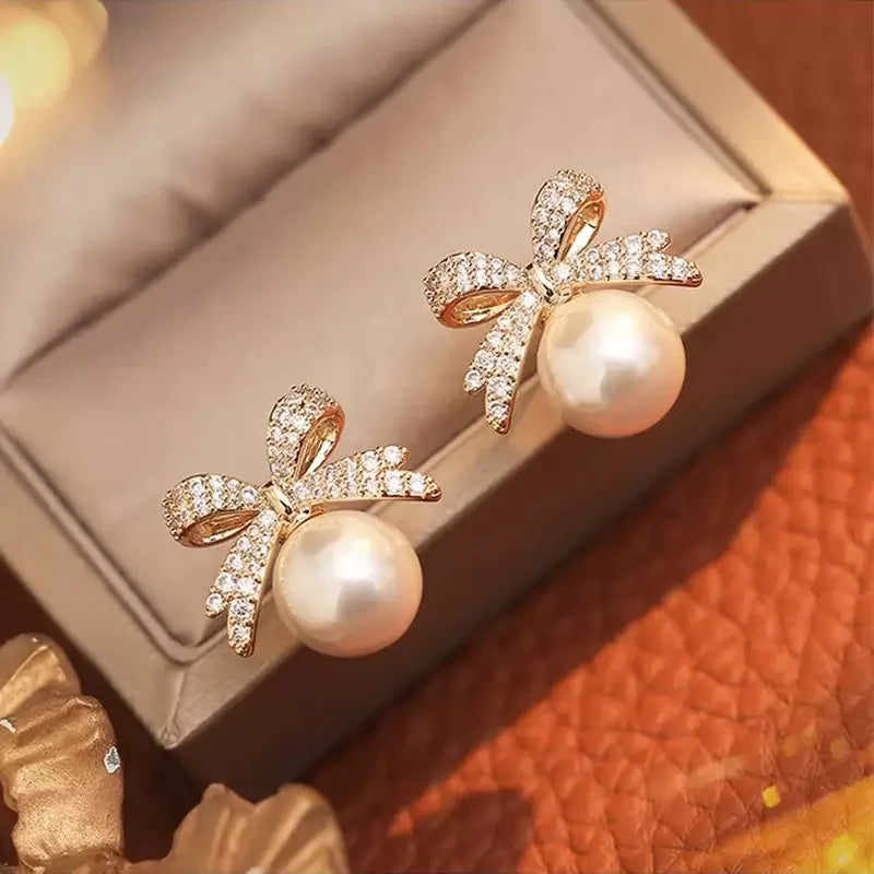 The 2025 high-quality retro and elegant earrings are diamond-encruffled bow pearl fashion earrings, suitable for the daily fresh