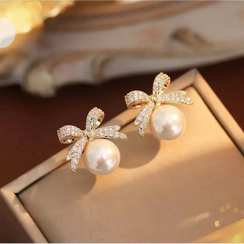 The 2025 high-quality retro and elegant earrings are diamond-encruffled bow pearl fashion earrings, suitable for the daily fresh